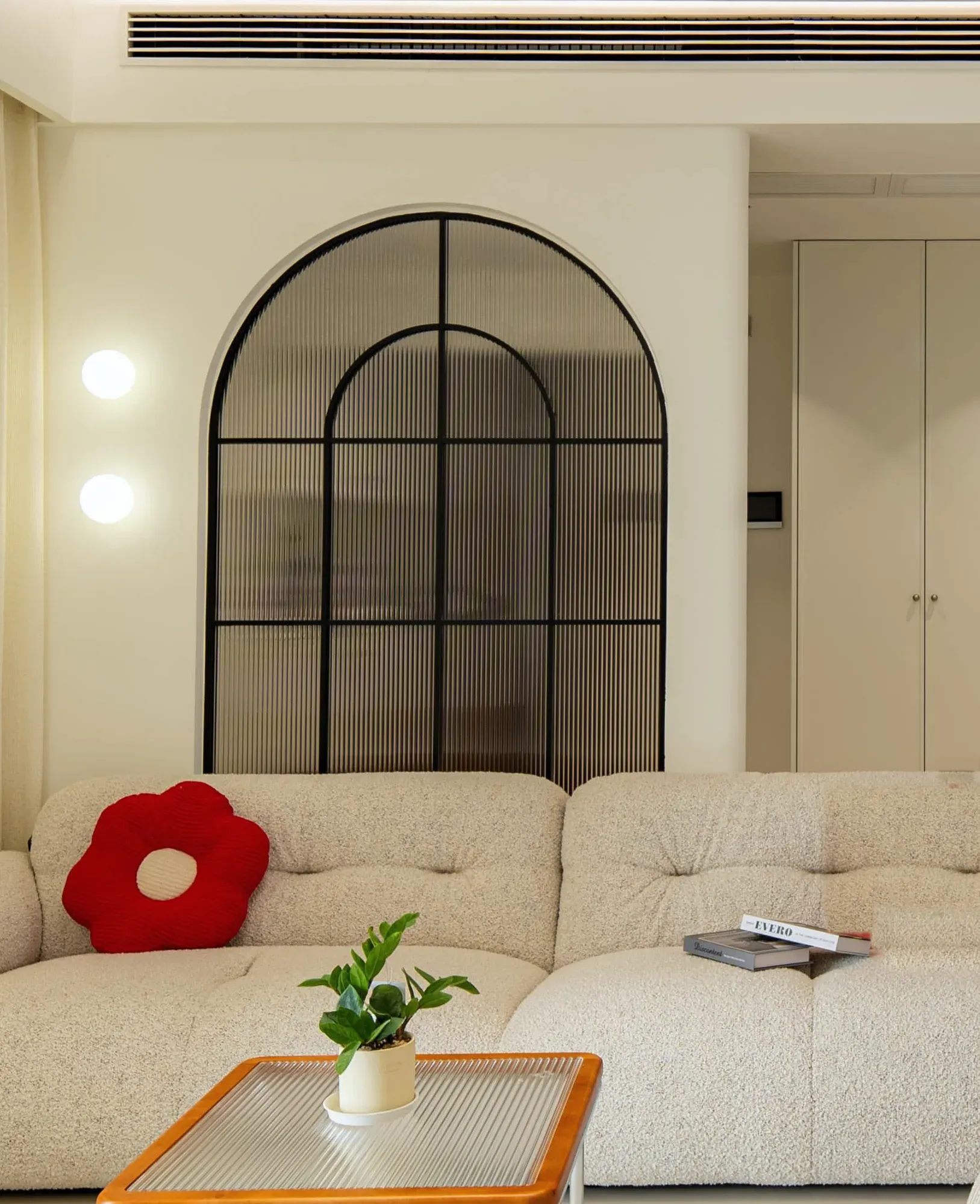 Arched glass entry partition with reeded glass and two round wall lights