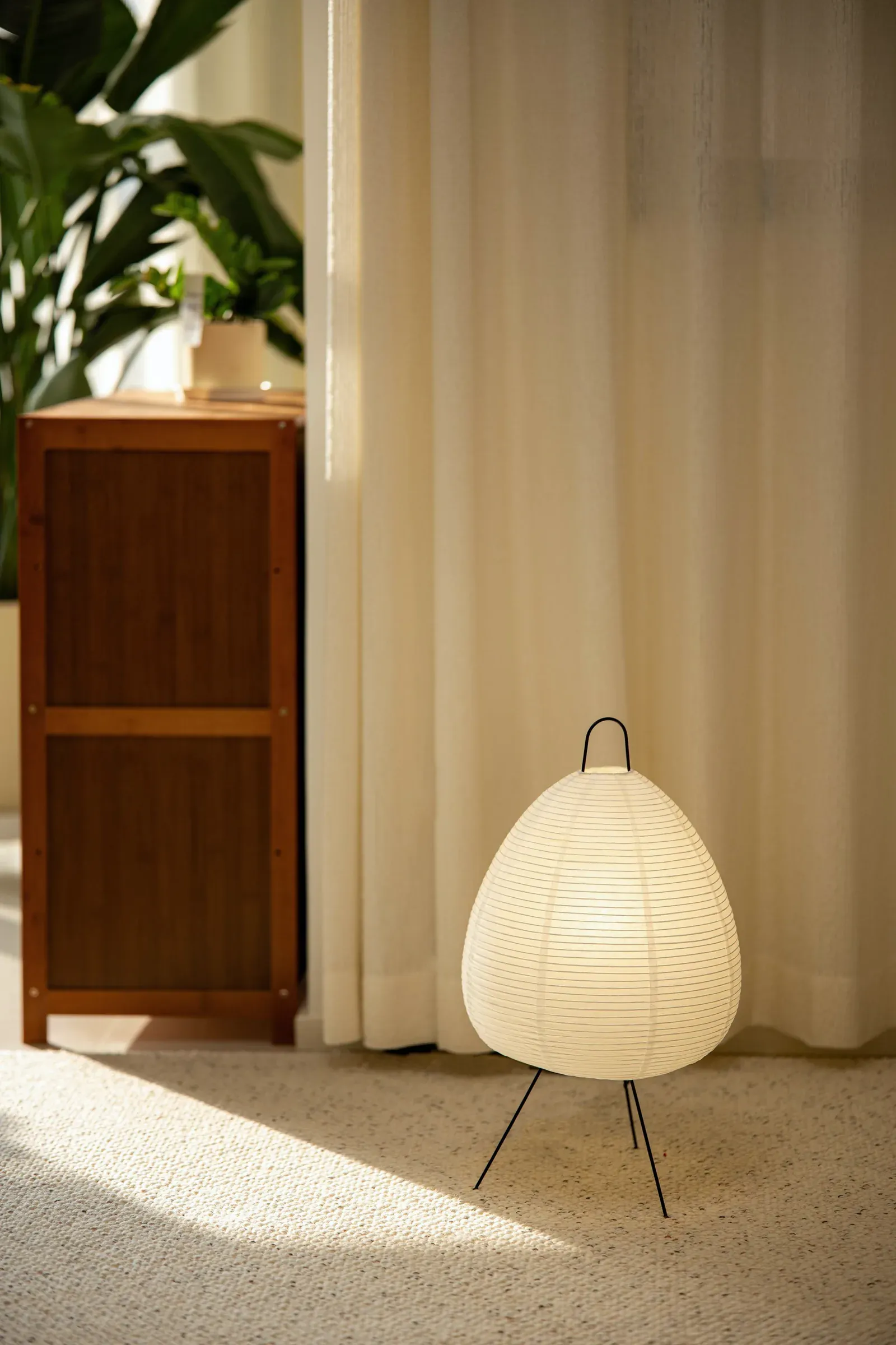 Living room corner with a paper lamp in afternoon light
