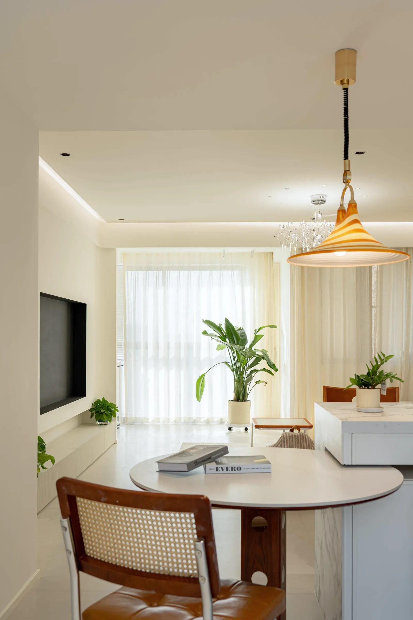 Round dining table by a window with sheer shades