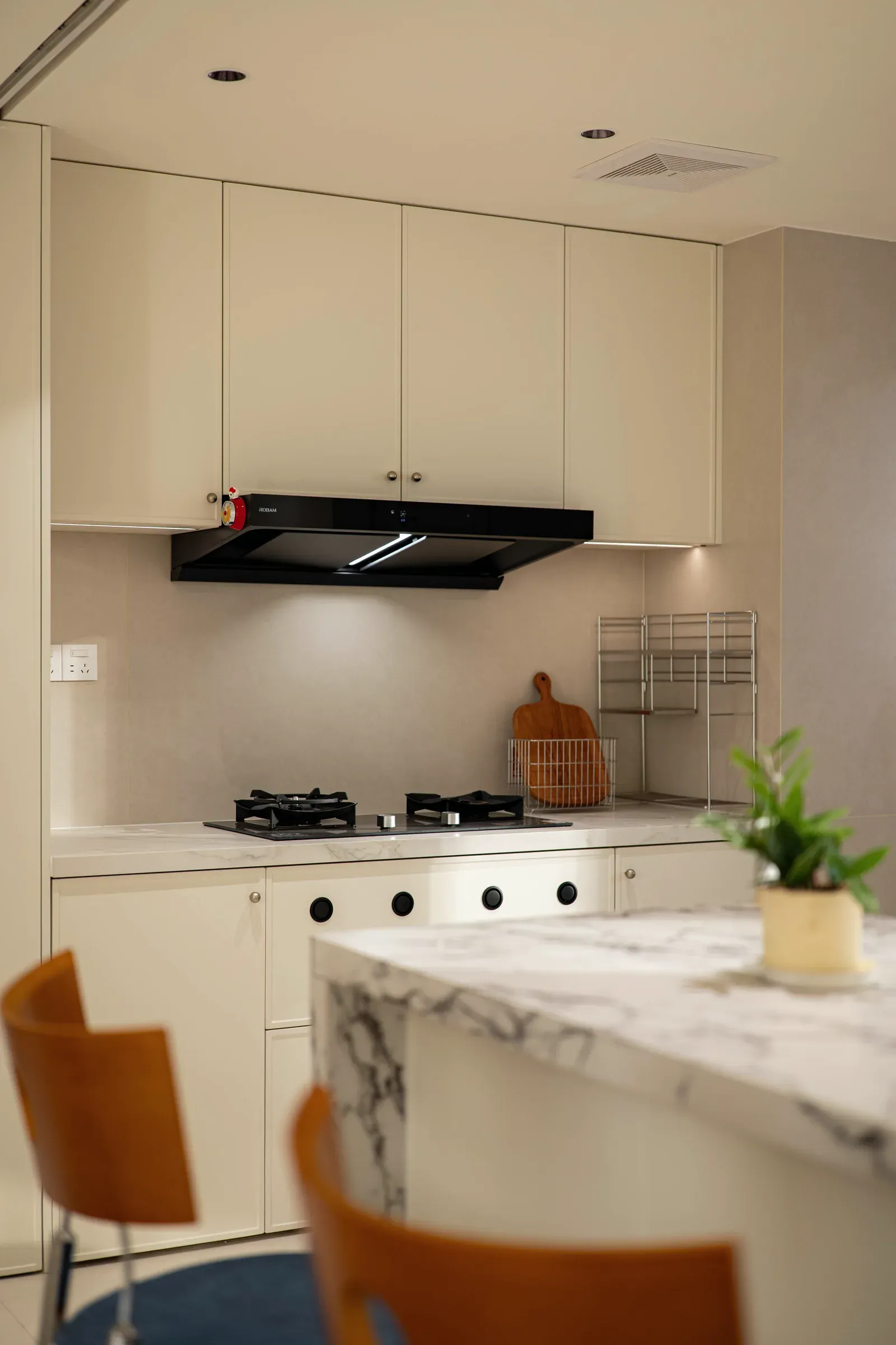 Kitchen with white upper and lower cabinets, a built-in cooktop and a recessed hood