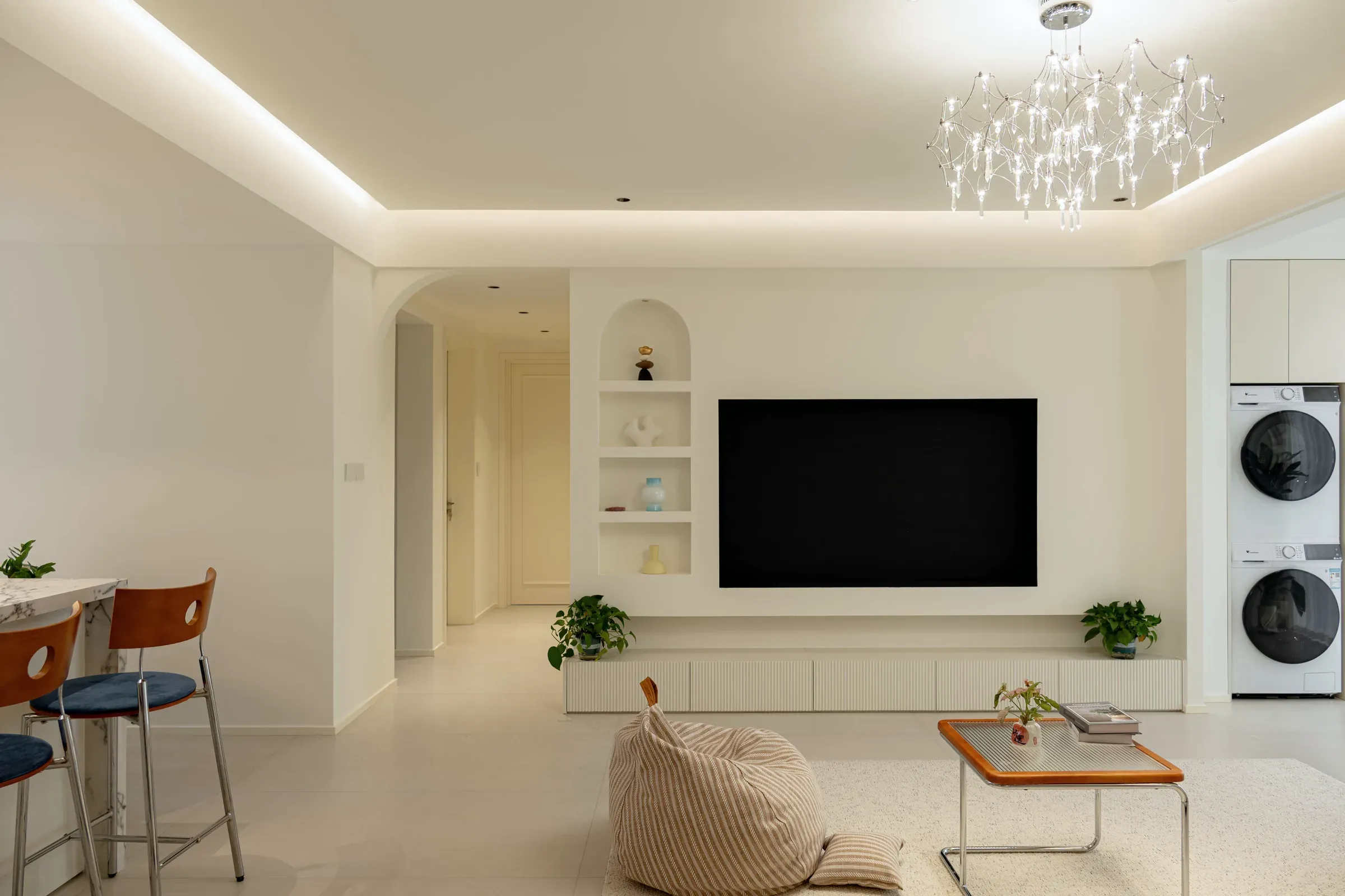 Living room with cove lighting and a doorway to the bedrooms