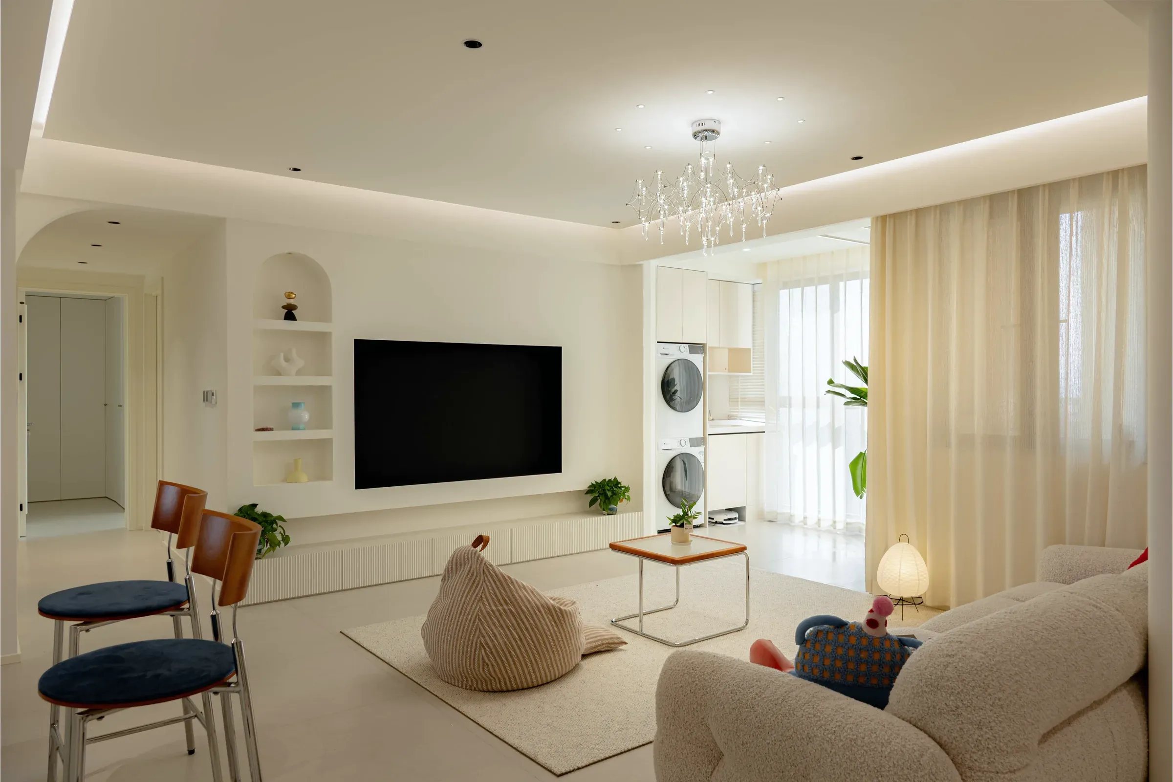 Living room toward the arched glass partition, the TV wall and the washer-dryer tower
