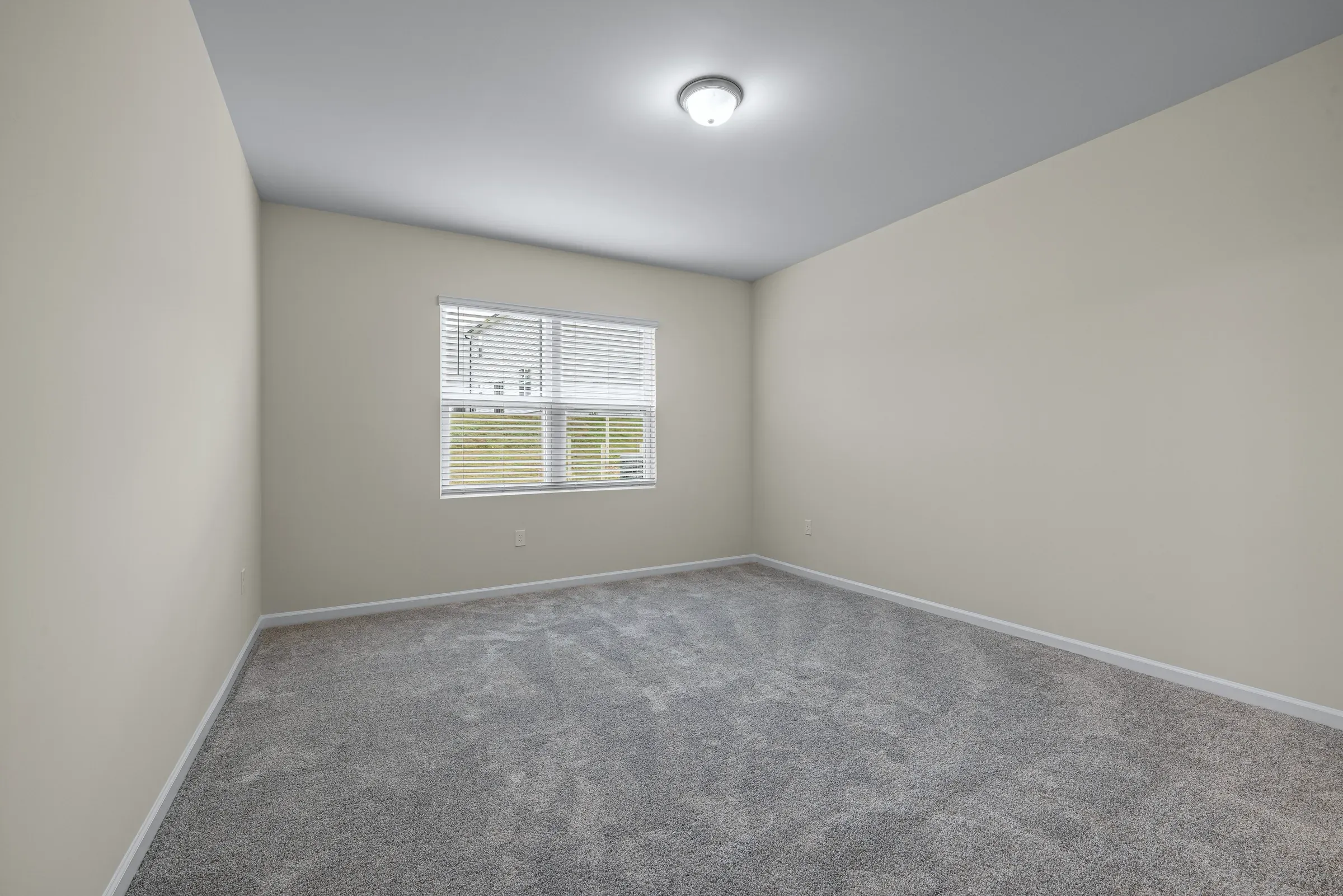 A typical Los Angeles apartment room with wall-to-wall carpet and one ceiling light