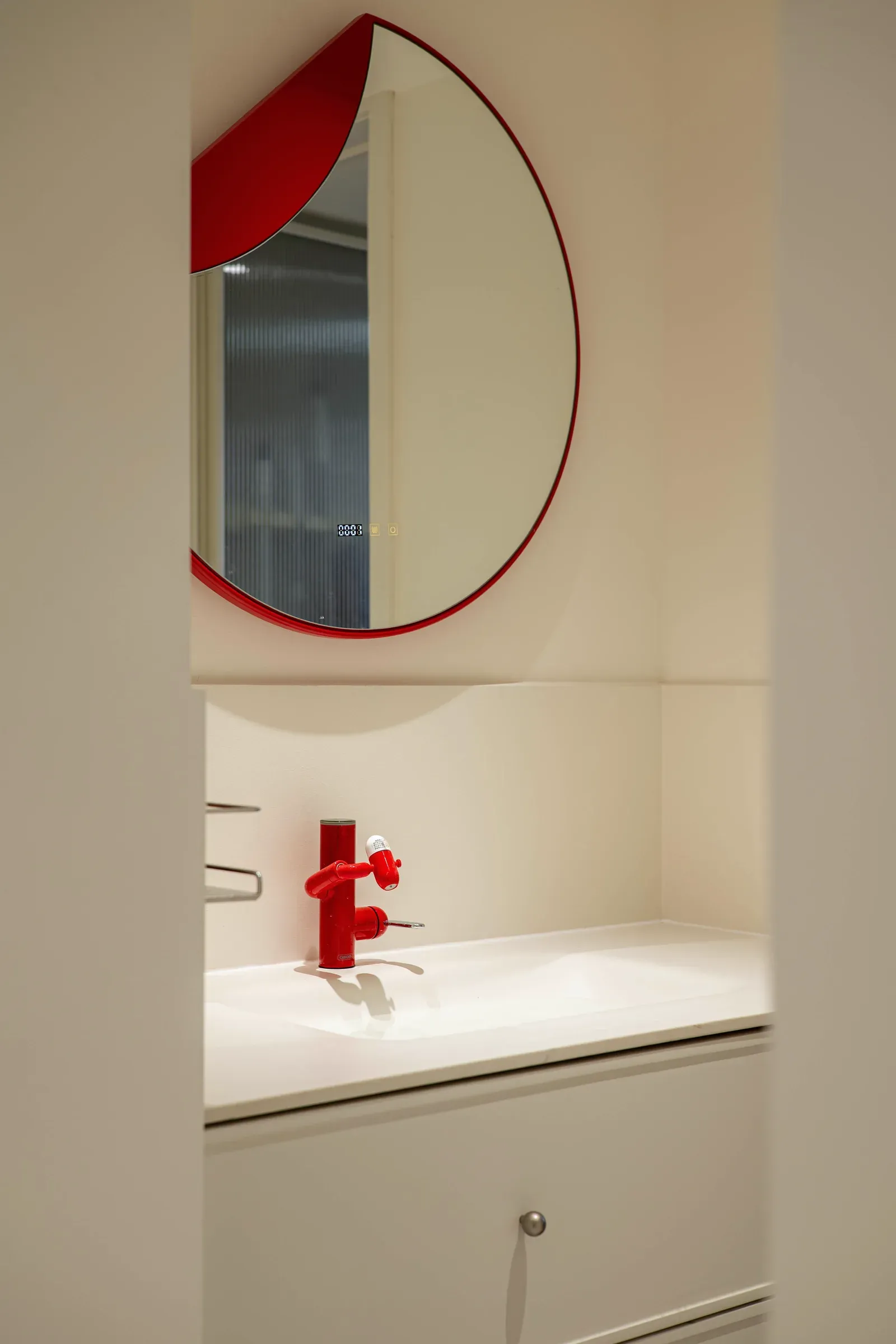 Vanity set into a wall niche with a round mirror